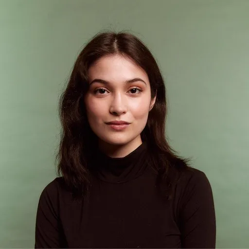 A person with curly hair wearing a dark shirt.